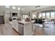 Kitchen island with seating looks out to living space with fireplace, dining area and staircase at 4372 Persian St, Greenwood, IN 46143