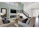 Bright living room boasts a fireplace, high ceilings, modern decor, and an open staircase at 4400 Persian St, Greenwood, IN 46143