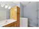 Bathroom featuring wood cabinets, large mirror, modern lighting, and neutral color palette at 455 S Pine St # 4, Indianapolis, IN 46203