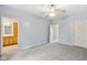 A spacious bedroom with gray carpet and a glimpse into an adjacent bathroom at 455 S Pine St # 4, Indianapolis, IN 46203