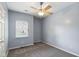 Neutral bedroom with a large window with a ceiling fan and gray carpeting at 455 S Pine St # 4, Indianapolis, IN 46203