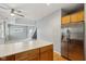 Open concept kitchen featuring wooden cabinets, stainless refrigerator and a staircase at 455 S Pine St # 4, Indianapolis, IN 46203