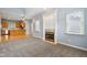 Open-concept living space with a fireplace, wood floors in kitchen, and carpeted area at 455 S Pine St # 4, Indianapolis, IN 46203