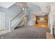 Open-concept living room with staircase and view of a modern kitchen with wood cabinets and floors at 455 S Pine St # 4, Indianapolis, IN 46203