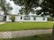 Charming single-story home with white siding, blue shutters, and manicured front lawn at 4617 Autumn Ridge Dr, Columbus, IN 47203