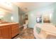 Bright bathroom featuring a soaking tub, vanity with wooden cabinets, and a separate shower at 4641 Autumn Ridge Dr, Columbus, IN 47203