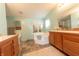 Bright bathroom showcasing a corner tub, vanity with wooden cabinets, and decorative tile flooring at 4641 Autumn Ridge Dr, Columbus, IN 47203