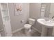 Clean and bright half bathroom features a pedestal sink, white toilet, decorative shelving, and neutral wall paint at 4863 Sherlock Dr, Westfield, IN 46062