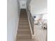 A carpeted staircase with decorative iron railings leads to an open-concept living area with a dining table and comfortable seating at 4863 Sherlock Dr, Westfield, IN 46062