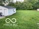 View of the backyard with a detached garage and lawn at 4943 S State Ave, Indianapolis, IN 46227
