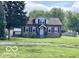 Charming home featuring a cozy front porch, complemented by mature trees and a well-maintained lawn at 4943 S State Ave, Indianapolis, IN 46227
