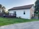 Home exterior shows an outside deck, partial brick facade, and white siding with green grass and blue sky at 4943 S State Ave, Indianapolis, IN 46227