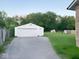 View of the white garage along a driveway with trees and partial view of home at 4943 S State Ave, Indianapolis, IN 46227