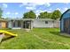 Backyard view showcasing well-maintained lawn, a large patio, and mature trees, perfect for outdoor enjoyment at 5115 Bertha St, Indianapolis, IN 46241
