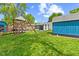 Spacious backyard featuring a playset, lush lawn, shade trees, and a charming storage shed at 5115 Bertha St, Indianapolis, IN 46241