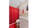 Bathroom with a shower behind a red curtain, toilet, and vanity at 5115 Bertha St, Indianapolis, IN 46241