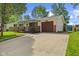 Ranch-style home featuring a spacious driveway, brick accents, and an attached single-car garage at 5115 Bertha St, Indianapolis, IN 46241