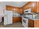 Kitchen featuring wooden cabinets, gray counters, tiled backsplash, and appliances at 5115 Bertha St, Indianapolis, IN 46241