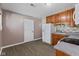 Kitchen featuring wooden cabinets, gray counters, tiled backsplash, appliances, and door at 5115 Bertha St, Indianapolis, IN 46241