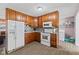 Kitchen featuring wooden cabinets, gray counters, tiled backsplash, and appliances at 5115 Bertha St, Indianapolis, IN 46241
