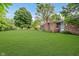 Spacious backyard featuring lush green grass and a brick home at 530 Westmore Dr, Indianapolis, IN 46214