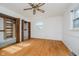Bright bedroom with ceiling fan, closet, hardwood floors, and abundant light from the windows at 530 Westmore Dr, Indianapolis, IN 46214