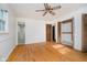 Empty bedroom with hardwood flooring, closet, ceiling fan, and ensuite bath access at 530 Westmore Dr, Indianapolis, IN 46214