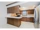 Retro kitchen featuring brown cabinets, white countertops, and a breakfast bar needing refurbishment at 530 Westmore Dr, Indianapolis, IN 46214