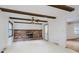 Living room with exposed ceiling beams, brick fireplace, and neutral walls offering a blank canvas at 530 Westmore Dr, Indianapolis, IN 46214