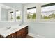 Bright bathroom featuring double sinks with a wood cabinet and two windows overlooking the backyard at 538 N East St, Greenfield, IN 46140