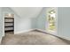 Bright bedroom featuring carpeted floors, walk-in closet, and a window with a view of the neighborhood at 538 N East St, Greenfield, IN 46140