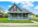 Charming two-story home featuring a covered front porch, red shutters, and a well-manicured lawn at 538 N East St, Greenfield, IN 46140