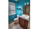 Bright bathroom featuring blue walls, a window with blinds, and a wooden vanity at 5433 Brendonridge Rd, Indianapolis, IN 46226