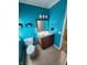 Bright bathroom with light tile floor, vibrant blue walls, and modern vanity at 5433 Brendonridge Rd, Indianapolis, IN 46226