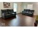 Inviting living room features dark wood floors, lots of natural light, and plush couches at 5433 Brendonridge Rd, Indianapolis, IN 46226