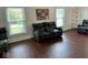 Comfortable living room features dark wood floors, natural light, and a plush reclining couch at 5433 Brendonridge Rd, Indianapolis, IN 46226