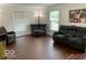 Comfortable living room features dark wood floors, natural light, and plush reclining couches at 5433 Brendonridge Rd, Indianapolis, IN 46226