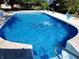Sparkling in-ground pool with concrete surround and manicured landscaping for relaxing outdoor enjoyment at 5433 Brendonridge Rd, Indianapolis, IN 46226