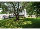 Lush backyard featuring a mature tree and a charming exterior view of the home, showcasing its serene outdoor setting at 5522 Closser Ct, Indianapolis, IN 46221
