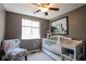 Bright Bedroom with a white crib, changing table, and a large window for natural light, creating a serene space at 5522 Closser Ct, Indianapolis, IN 46221