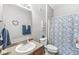 Well-lit bathroom features a sink, toilet, and shower with a blue patterned curtain, providing a functional space at 5619 Payne Blvd, Plainfield, IN 46168