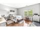 Spacious bedroom showcasing hardwood floors, a window for natural light, and ample space for a desk and treadmill at 5619 Payne Blvd, Plainfield, IN 46168