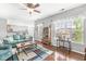 Bright living room features hardwood floors, a ceiling fan, and an open view of the eat-in kitchen at 5619 Payne Blvd, Plainfield, IN 46168