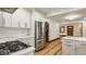 Bright kitchen featuring white cabinets, quartz countertops, stainless steel appliances, and a view of the stairs at 5622 Guilford Ave, Indianapolis, IN 46220