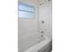 Bathroom featuring a classic white tub, white subway tile, and a window for natural light at 611 Hampton Ln, Anderson, IN 46017