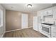 Bright kitchen features white cabinets, appliances, and wood-look flooring, creating a clean and modern space at 611 Hampton Ln, Anderson, IN 46017