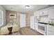 Kitchen and dining area with white cabinets, white appliances, and vinyl plank flooring at 611 Hampton Ln, Anderson, IN 46017