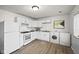 Bright kitchen features white cabinetry, appliances, with new washer and dryer, offering convenience and style at 611 Hampton Ln, Anderson, IN 46017