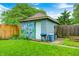 Backyard with a painted shed, lush green grass, privacy fence, and a grill for outdoor cooking at 752 N Leland Ave, Indianapolis, IN 46219