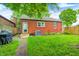 Brick home exterior with grassy backyard, grill, and access from the house with a privacy fence at 752 N Leland Ave, Indianapolis, IN 46219